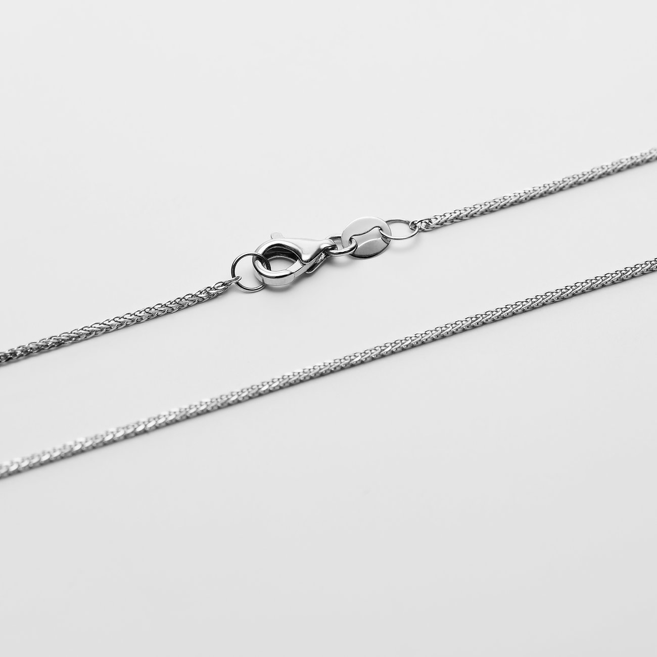 Nahaufnahme einer CHRIST Halskette aus 585er Weißgold mit einem Karabinerverschluss, scharf konturiert auf Weißgold.