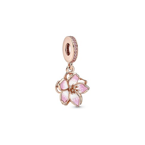 Pandora Anhänger aus Metall mit emaillierter rosa-weißer Blüte und Zirkonia Steinen, schräg von oben aufgenommen.