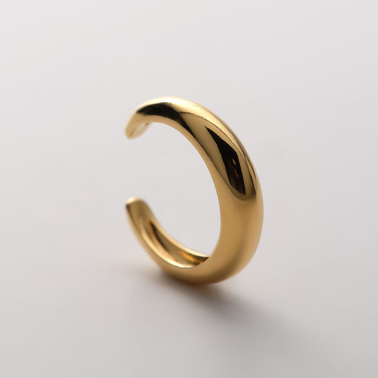 CHRIST Ohrschmuck: Glänzender, goldfarbener Ohrclip aus recyceltem Silber von vorne, leicht nach rechts geneigt.