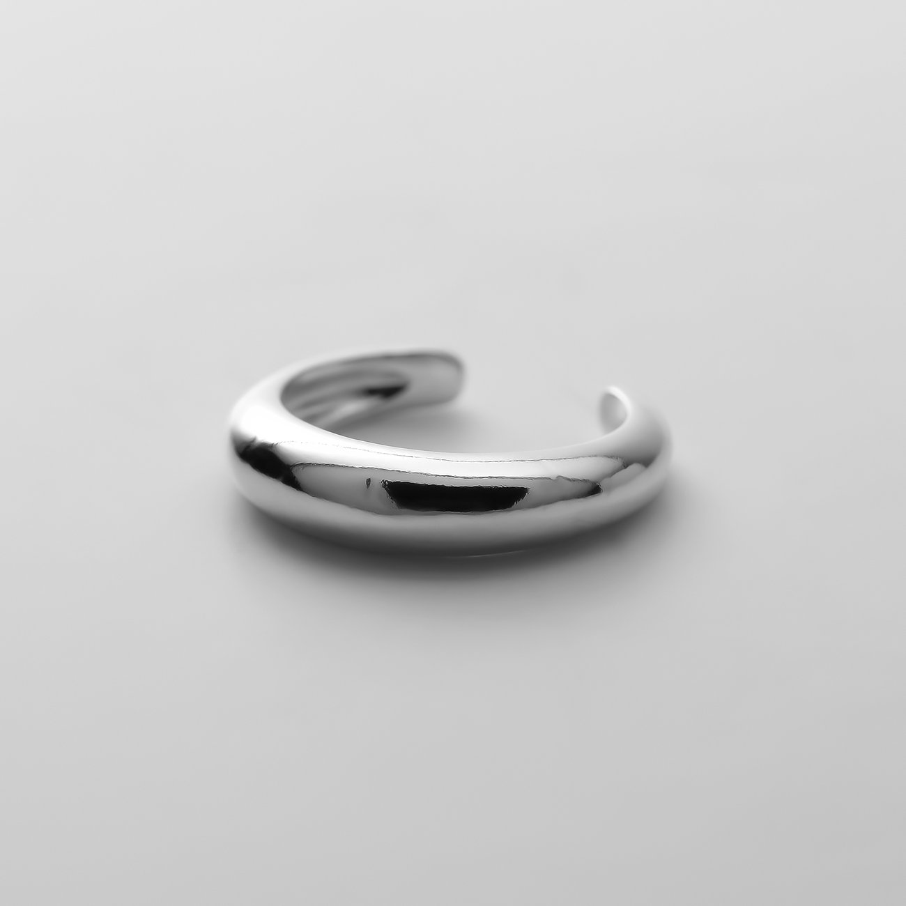 CHRIST Ohrschmuck aus recyceltem 925er Silber. Eine schlanke gebogene offene Manschette in reflektierendem Glanz.