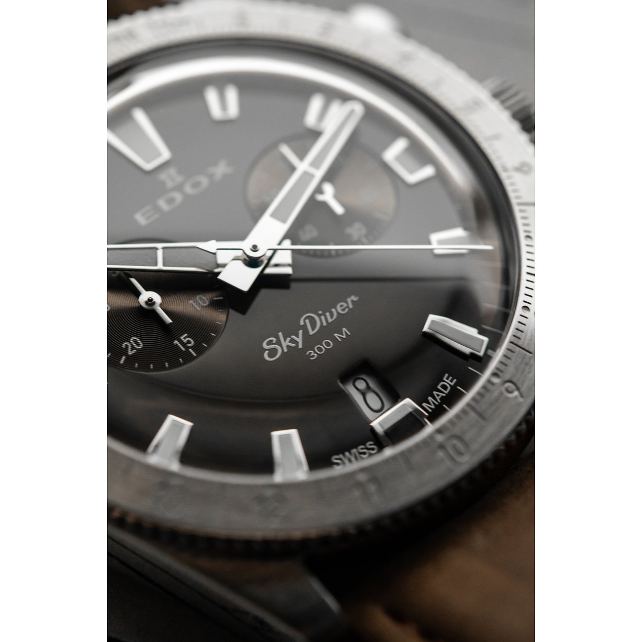 Nahaufnahme des Zifferblatts einer Edox Sky Diver Herrenuhr aus silberfarbenem Edelstahl und Aluminium.