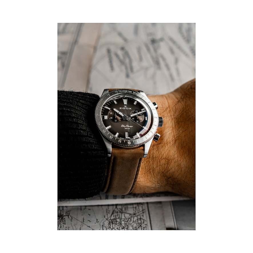 Am Handgelenk getragene Edox Sky Diver Herrenuhr aus Edelstahl und Aluminium mit braunem Uhrband.