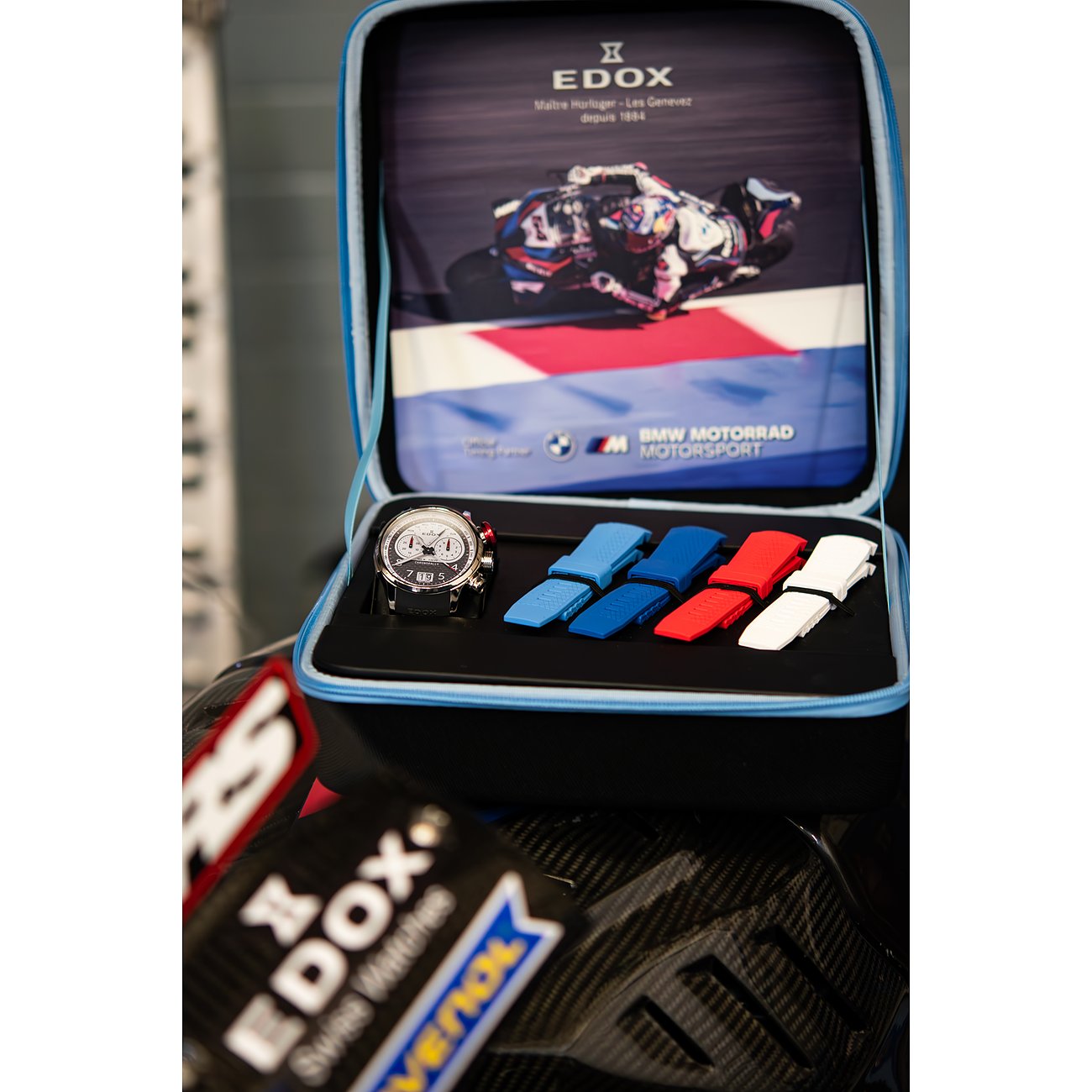 Edox Uhren-Set mit mehrfarbigen Aluminium- und Titanarmbändern in einer blauen Box mit Motorsport-Motiv.