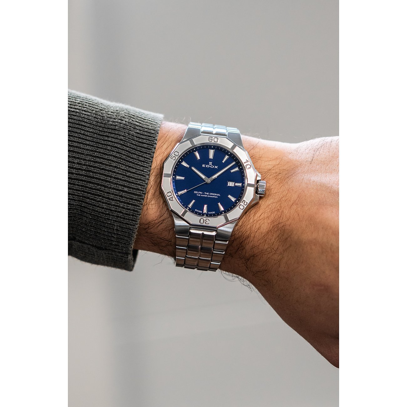 Am Handgelenk getragene Edox Herrenuhr aus blauem Aluminium und Edelstahl mit blauem Zifferblatt.