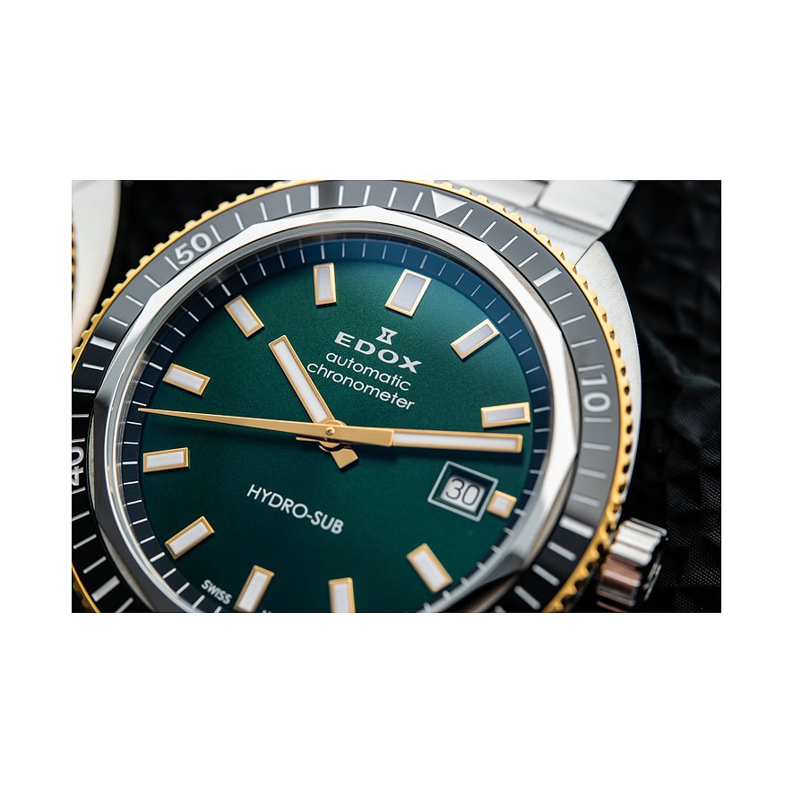 Detailansicht einer Edox Herrenuhr aus Edelstahl und Keramik mit grünem Zifferblatt und goldenen Akzenten.