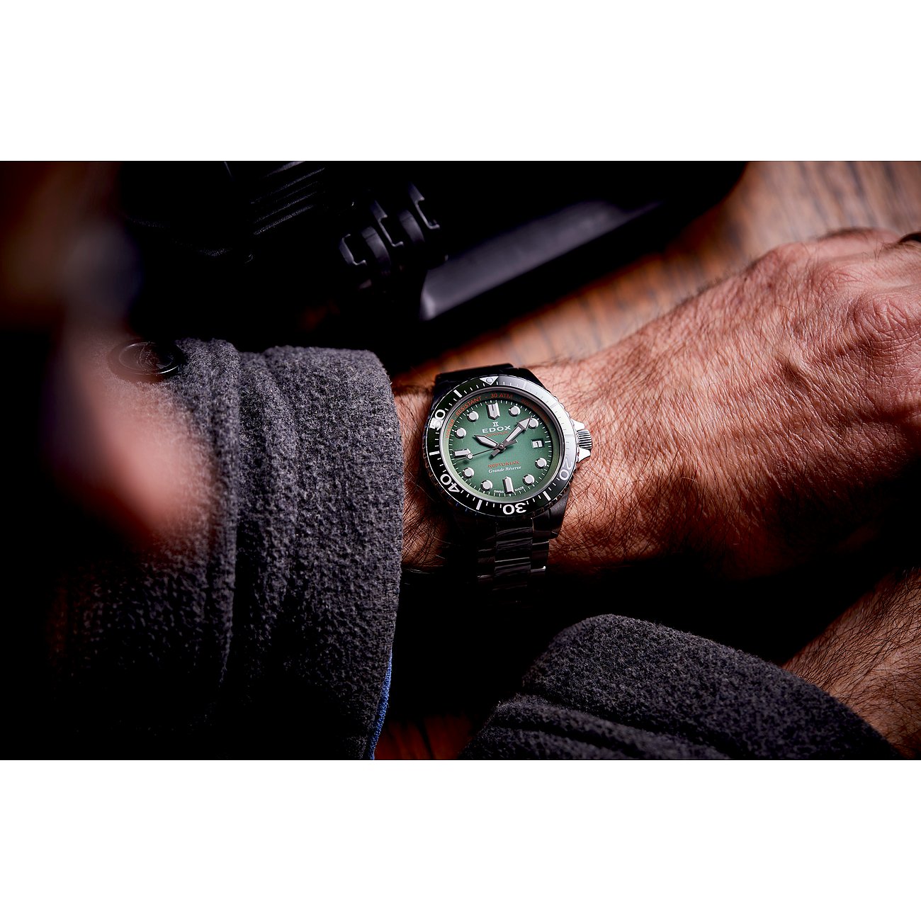 Nahaufnahme der Edox Grand Ocean Herrenuhr am Handgelenk eines Mannes, silbernes Edelstahlgehäuse, grünes Zifferblatt.
