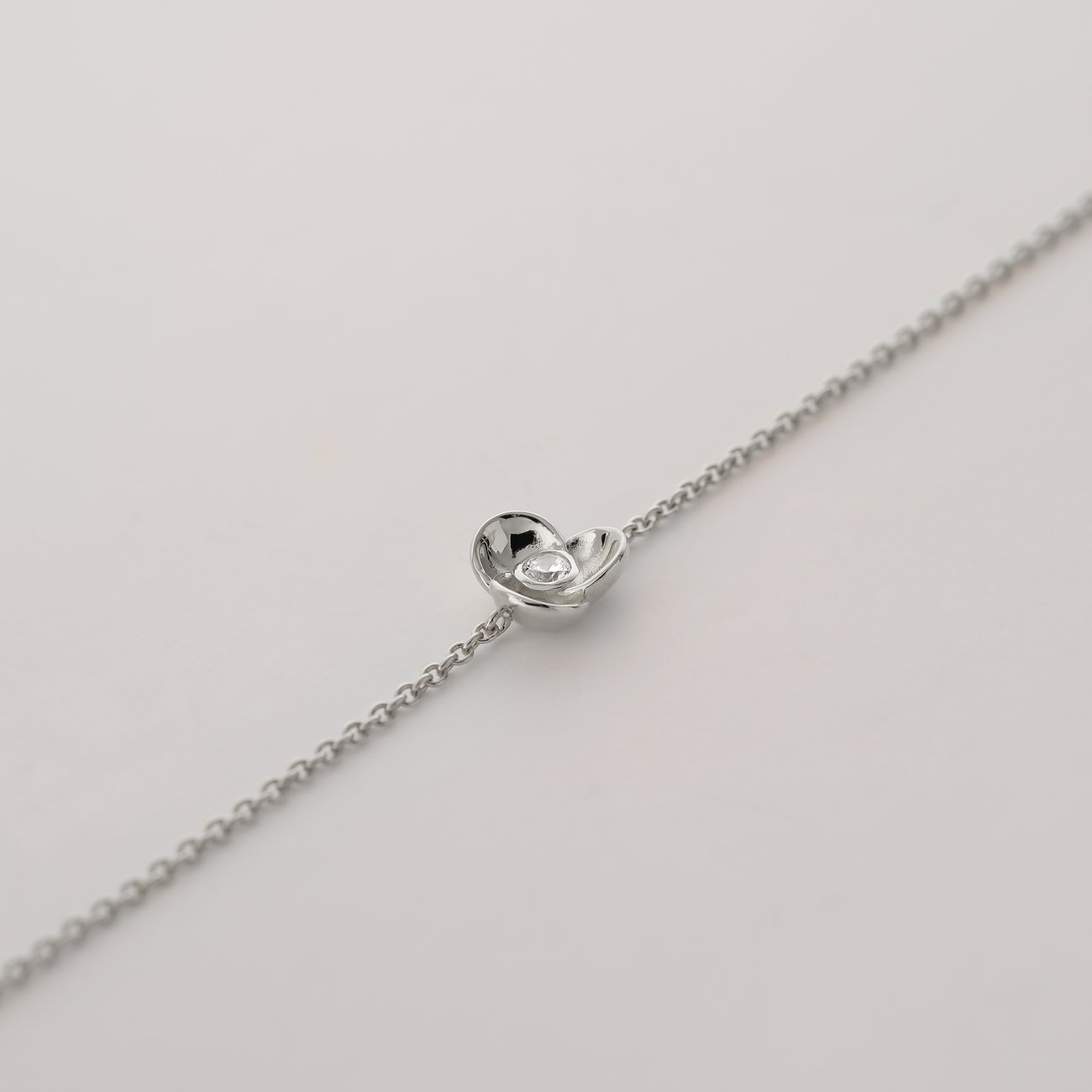 JETTE Armband aus recyceltem 925er Silber mit Herz und Zirkonia, diagonal liegend.