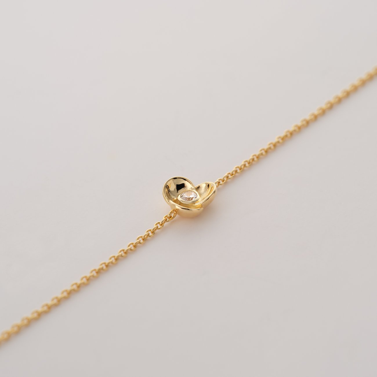 Et fint JETTE armbånd i genanvendt, forgyldt 925 sølv. En lille hjerte pryder kæden.