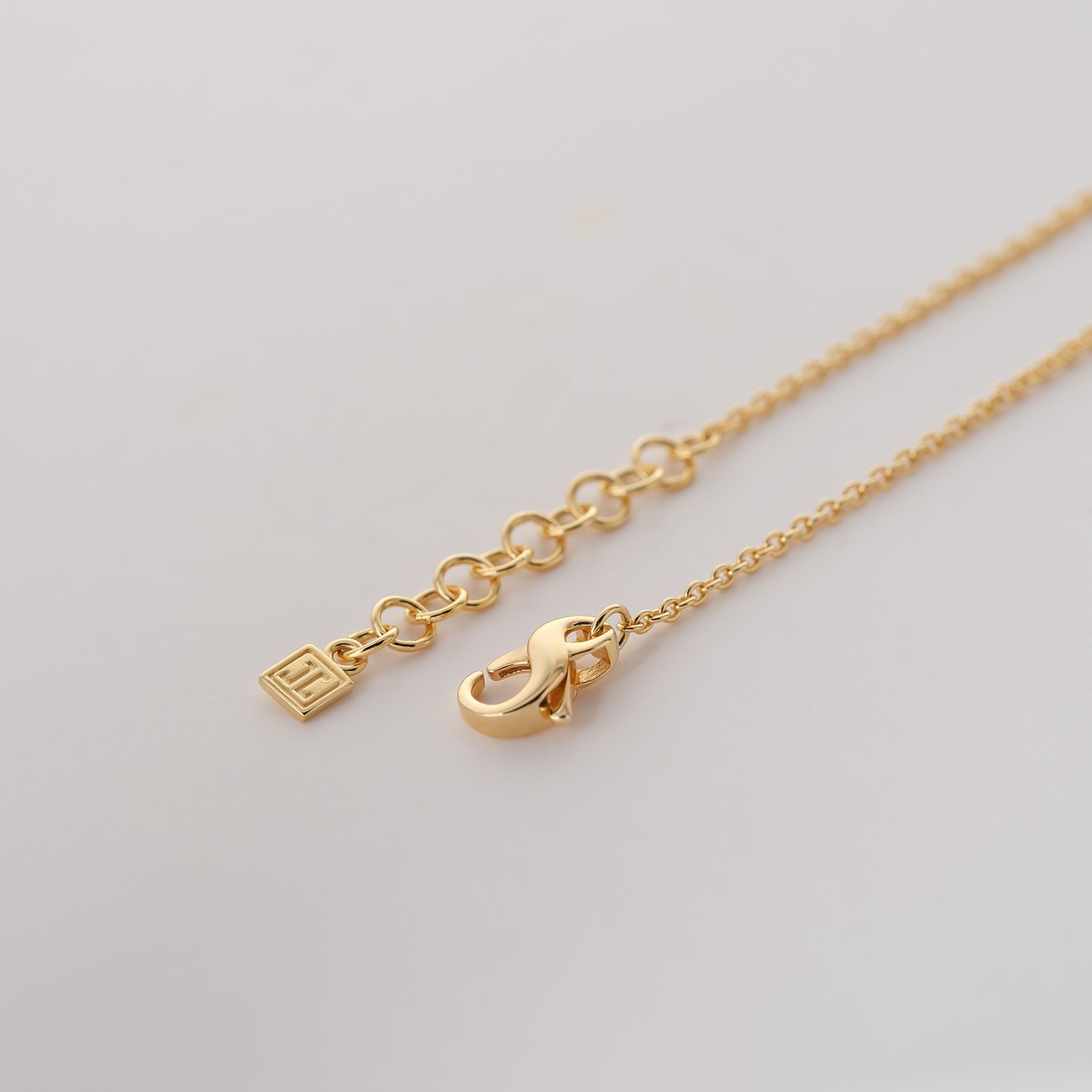 Nærbillede af JETTE armbåndskæde i genbrugssølv med justerbar kædelås og emblem.