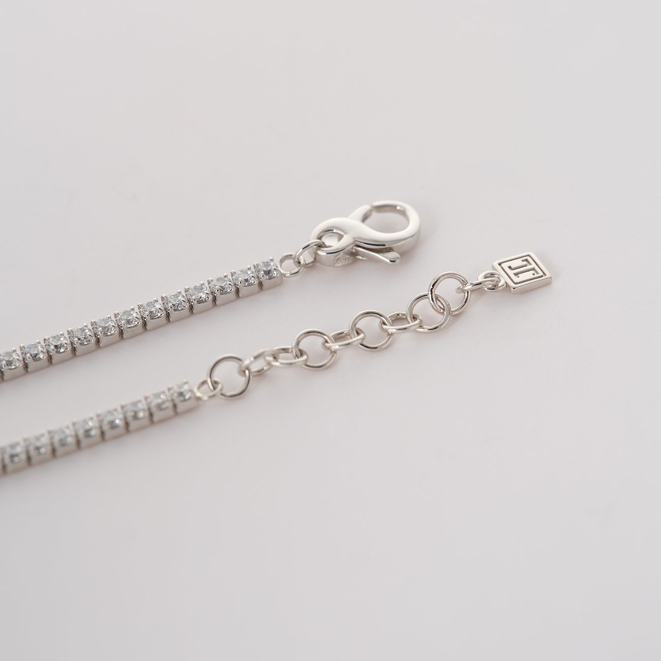 Nahaufnahme des Verschlusses eines JETTE Tennisarmbands aus recyceltem 925er Silber mit Zirkonia-Farbsteinen.