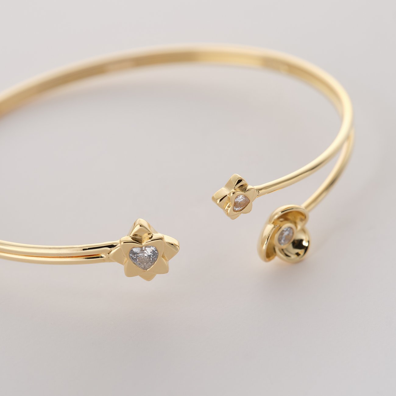 Nahaufnahme eines goldenen Armreifs von JETTE aus recyceltem 925er Silber mit offenen Enden.