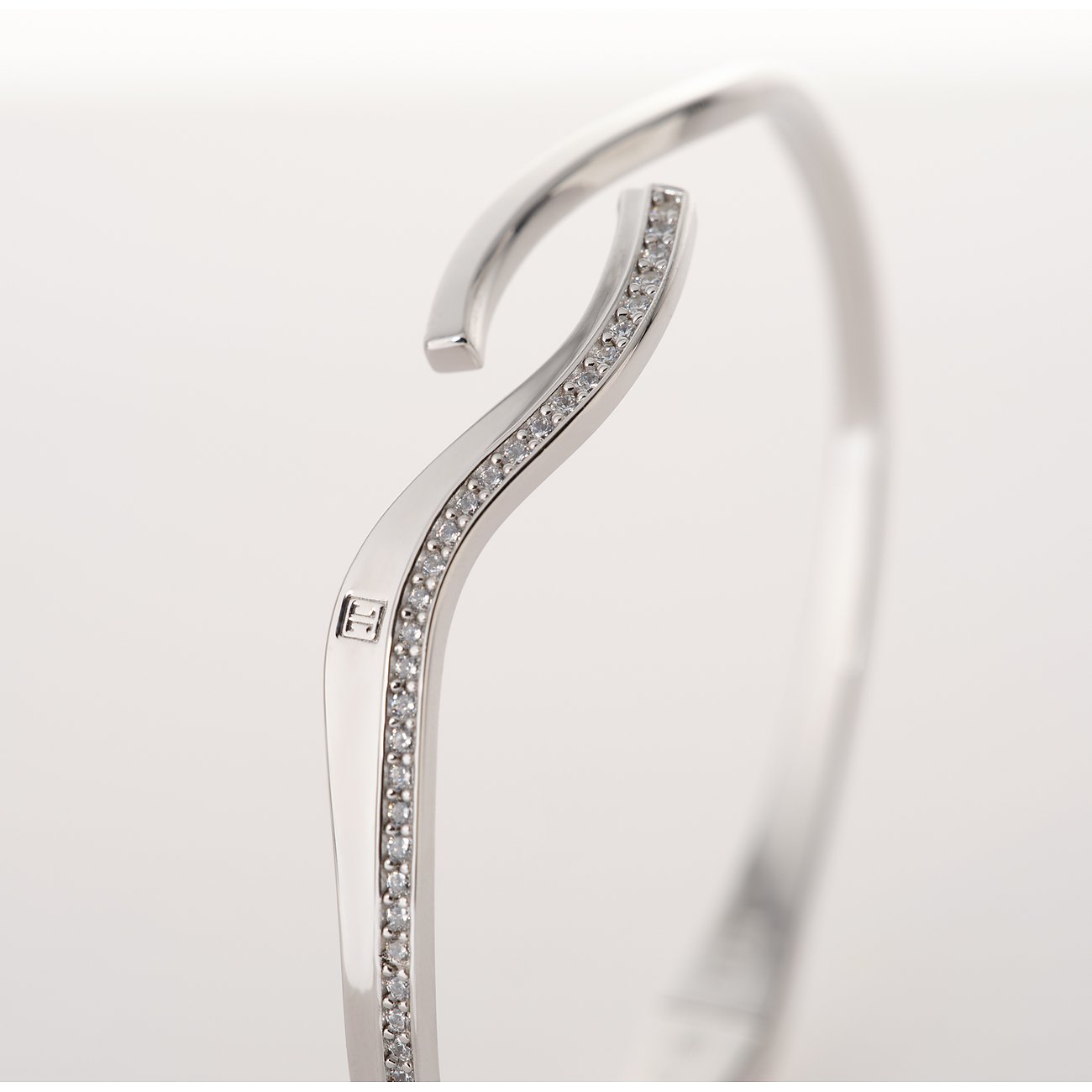 Nahaufnahme eines silbernen JETTE Armreifs aus recyceltem 925er Silber mit Zirkonia-Farbsteinen.