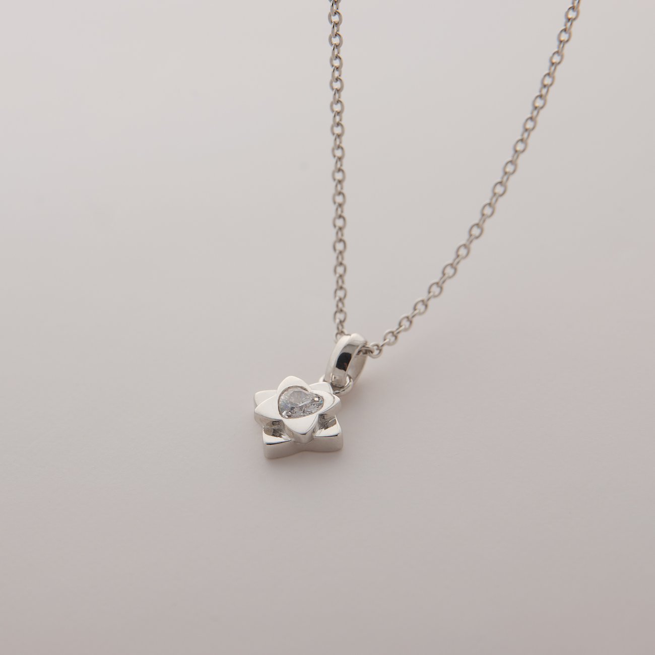 JETTE Halsschmuck aus recyceltem 925er Silber mit Zirkonia-Blütenanhänger, schräg von oben aufgenommen.