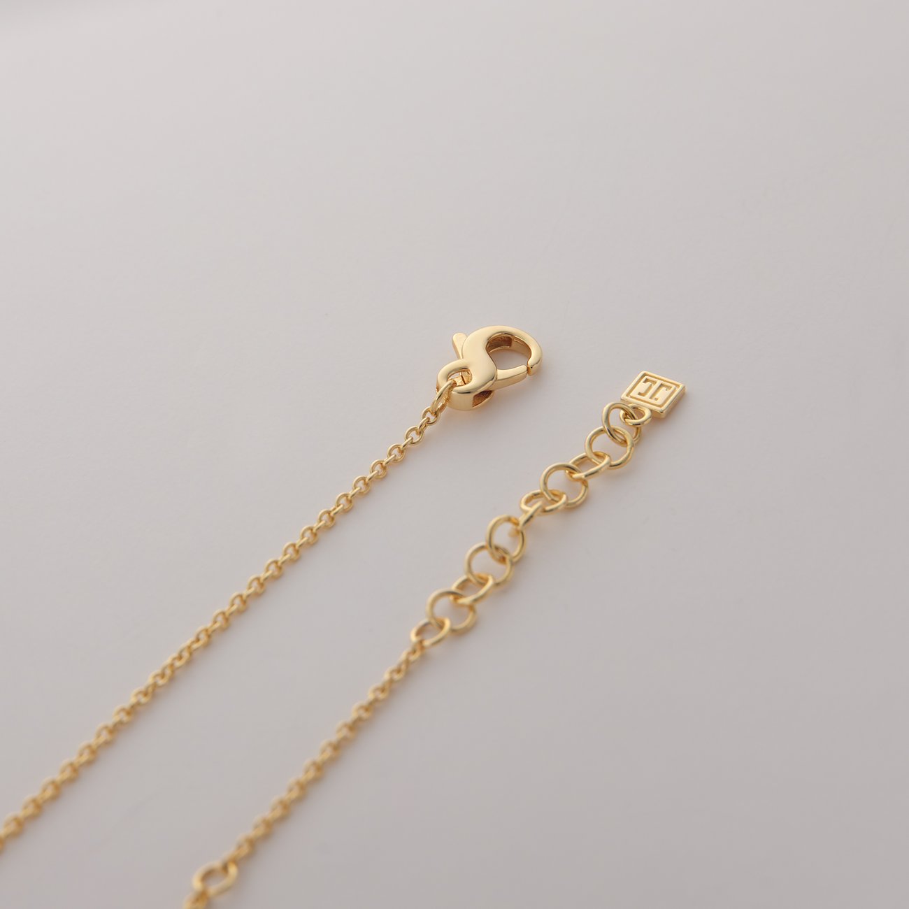 Nahaufnahme des Verschlusses einer JETTE Halskette aus recyceltem Silber mit goldener Beschichtung und Zirkonia.