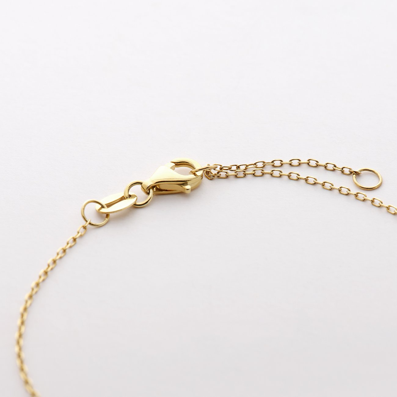 Nærbillede af karabinhagelåsen og forlængerkæden på CHRIST armbåndet i 585 guld.
