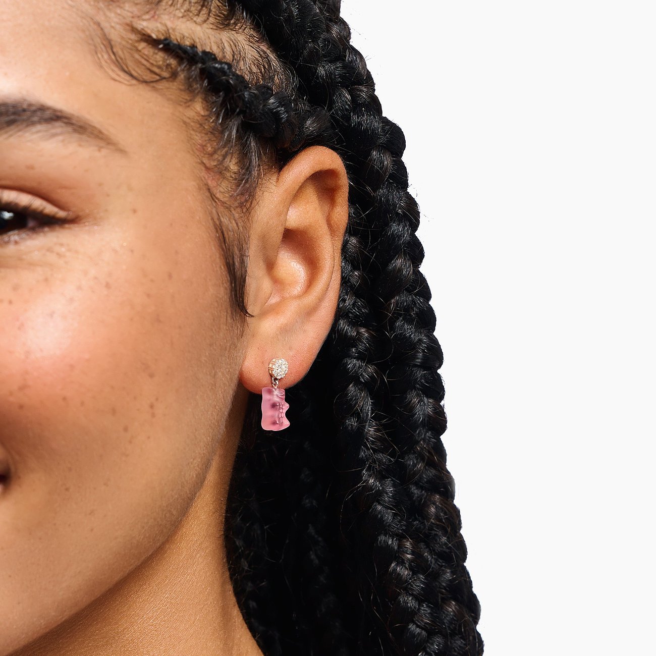 Thomas Sabo Bär-Ohrring aus Silber mit rosa Zirkonia, im Ohr einer Person, links im Bild Nahaufnahme des Gesichts.