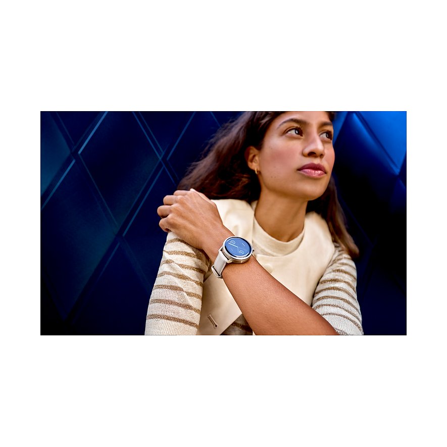 Eine Frau trägt eine Garmin Smartwatch aus Kunststoff mit weißem Armband am linken Handgelenk.