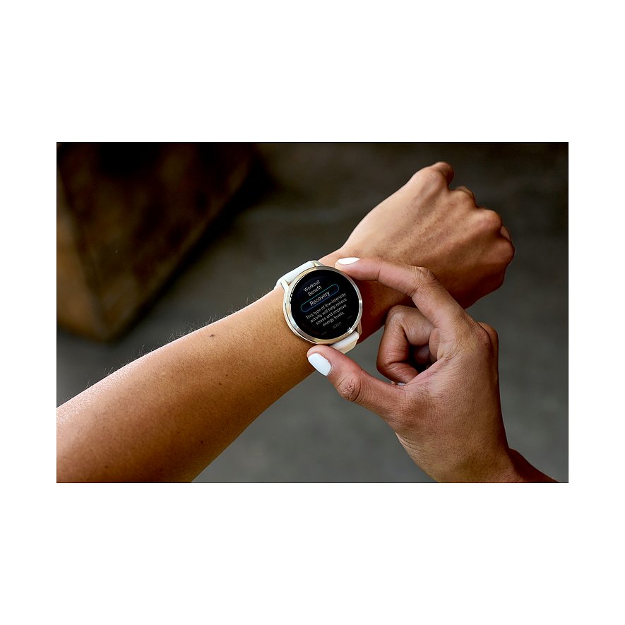 Eine Nahaufnahme zeigt eine Garmin Smartwatch aus weißem Kunststoff am Handgelenk einer Person, die den Bildschirm berührt.