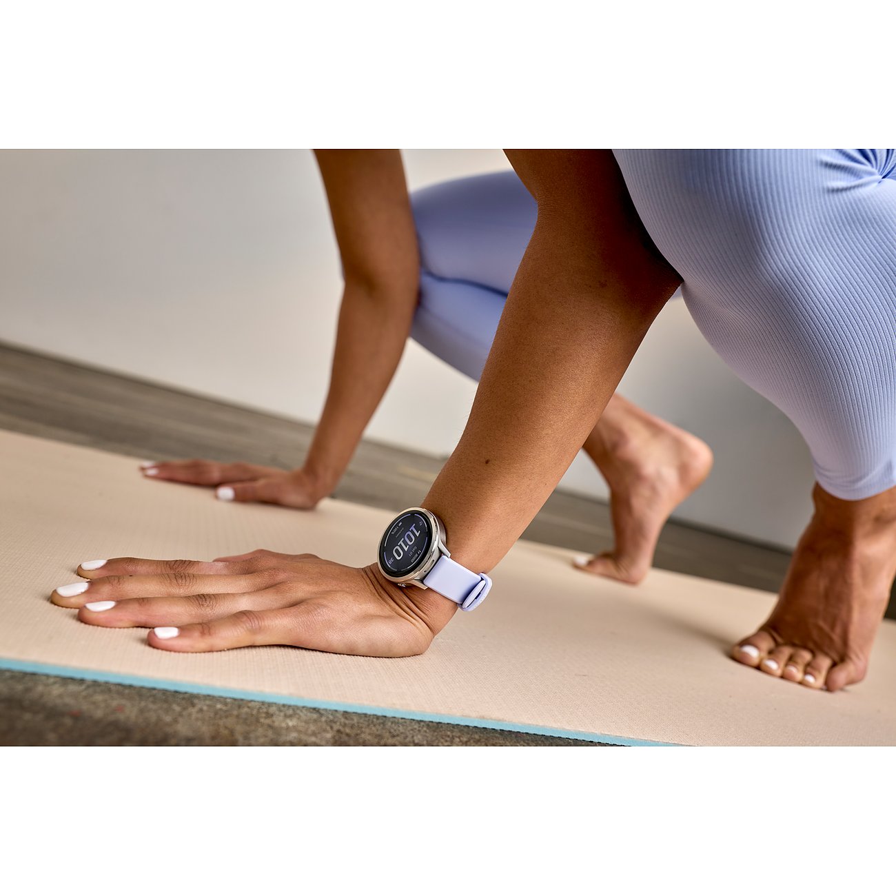 Eine Person macht Sport und trägt dabei eine Garmin Smartwatch aus Kunststoff mit lila Band am Handgelenk.
