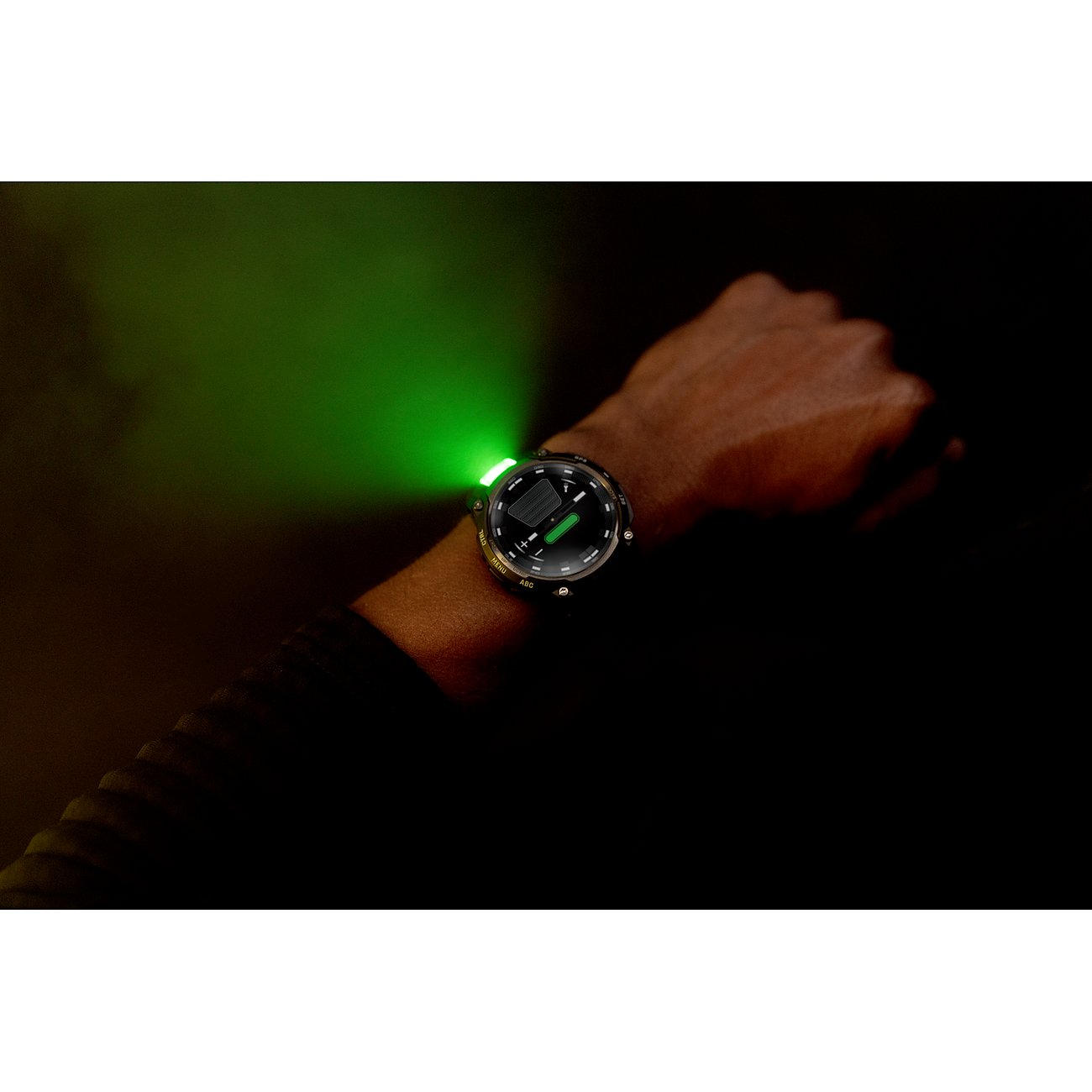 Eine Garmin Smartwatch aus Kunststoff am Handgelenk, die einen grünen Lichtkegel ausstrahlt, aus der Nähe.