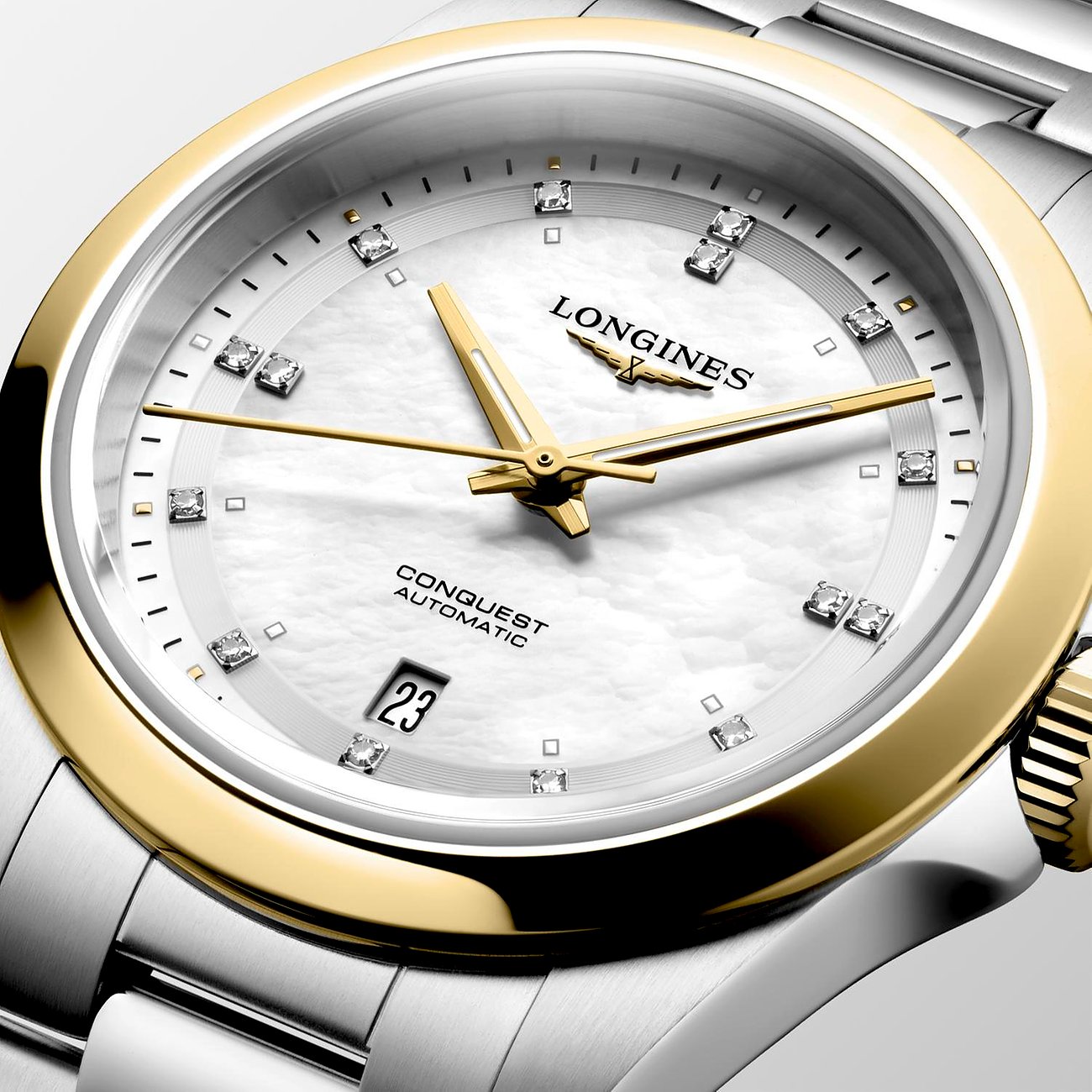 Die Longines Damenuhr aus Edelstahl hat ein perlmuttfarbenes Zifferblatt mit Diamanten und goldfarbenen Zeigern.
