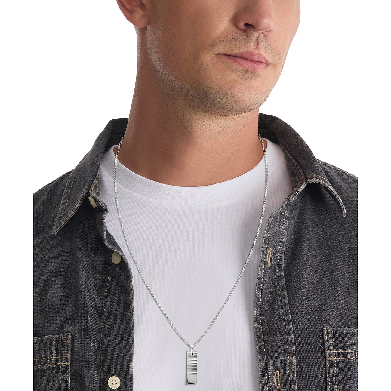 Man draagt een Calvin Klein roestvrijstalen ketting met een rechthoekige hanger met een pianotoetsenbordpatroon.