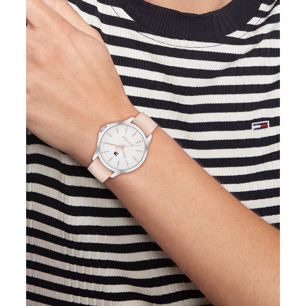 Tommy Hilfiger Damenuhr aus Edelstahl mit hellem Zifferblatt und rosafarbenem Glattlederarmband am Handgelenk.