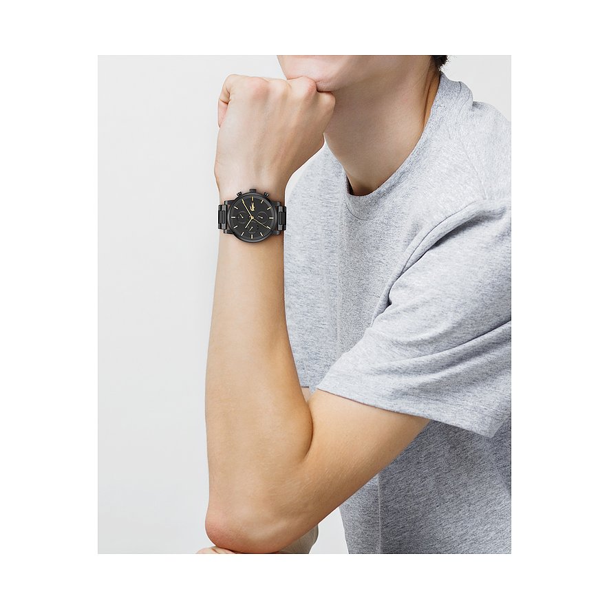 Am Handgelenk eines Mannes getragene schwarze Lacoste Herrenuhr aus Edelstahl mit Chronograph.
