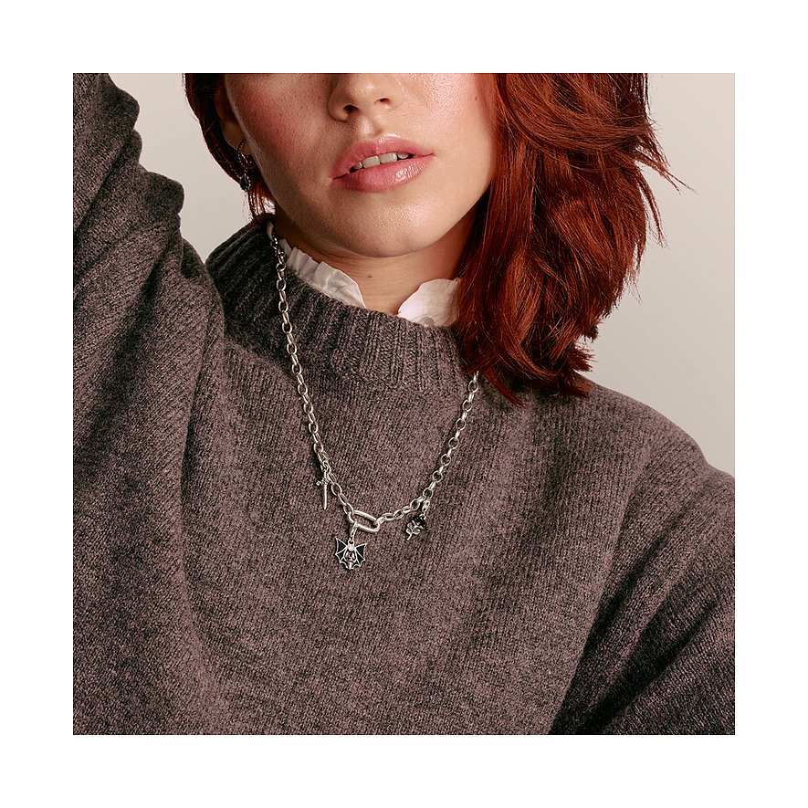 Primo piano di donna con capelli rossi che indossa una collana d'argento Thomas Sabo con pendenti.