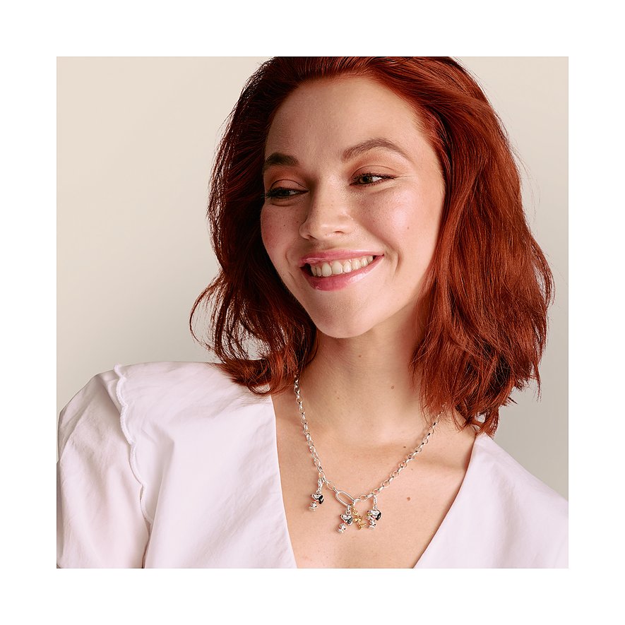 Eine lächelnde Frau trägt eine Thomas Sabo Anhängerkette aus 925er Silber mit mehreren Charms aus Silber und Emaille.