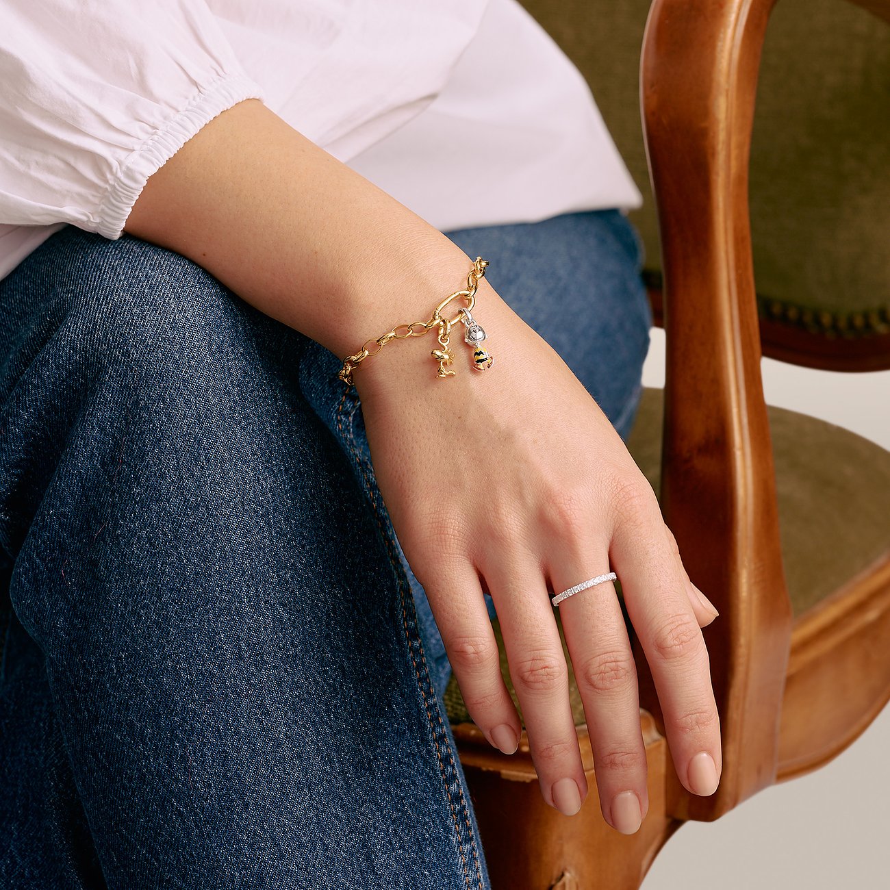 Una donna indossa un bracciale Thomas Sabo in argento al polso, insieme a un anello sottile.