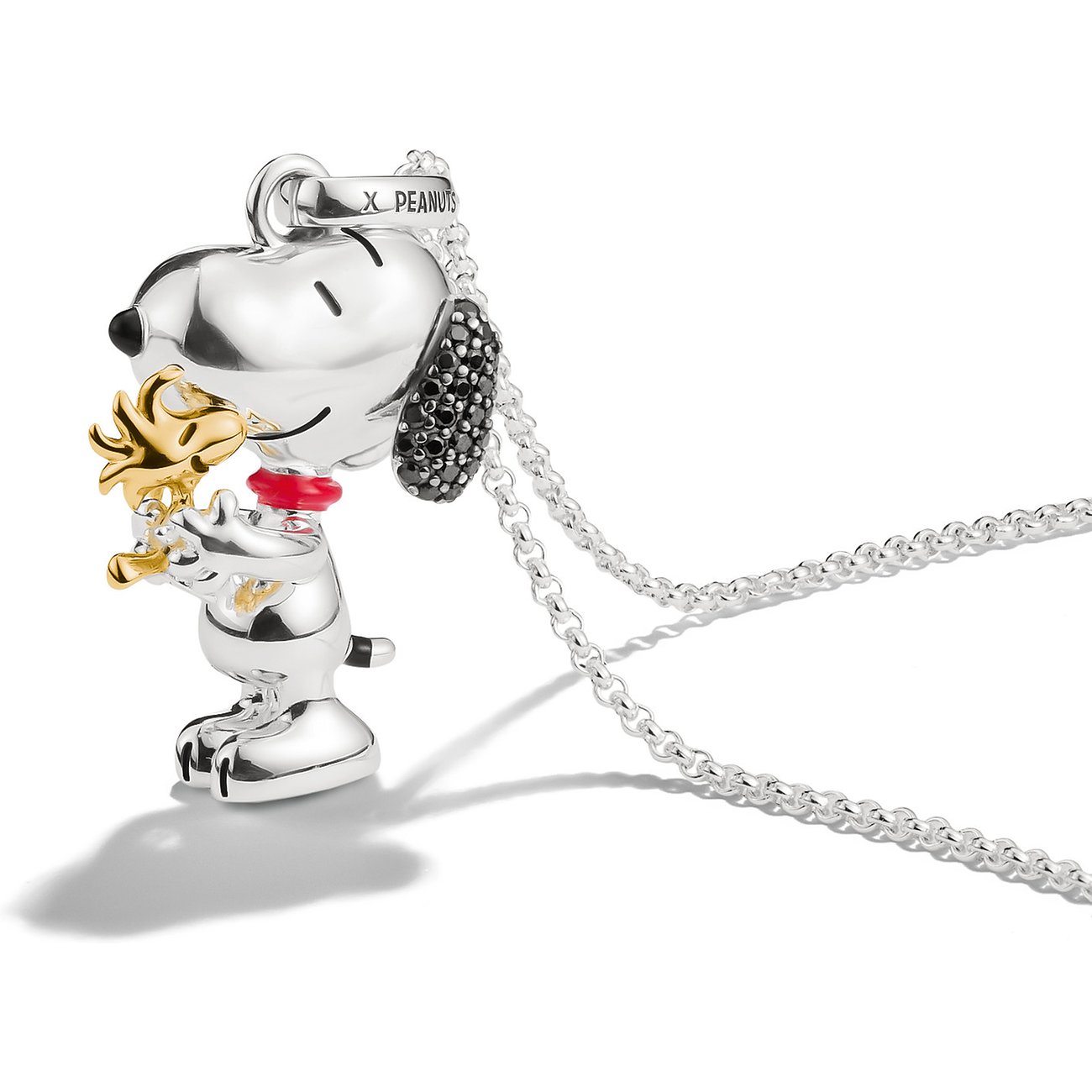 Thomas Sabo Halsschmuck aus 925er Silber zeigt Snoopy mit Goldakzenten und schwarzen Zirkonia-Ohren, der Woodstock hält.
