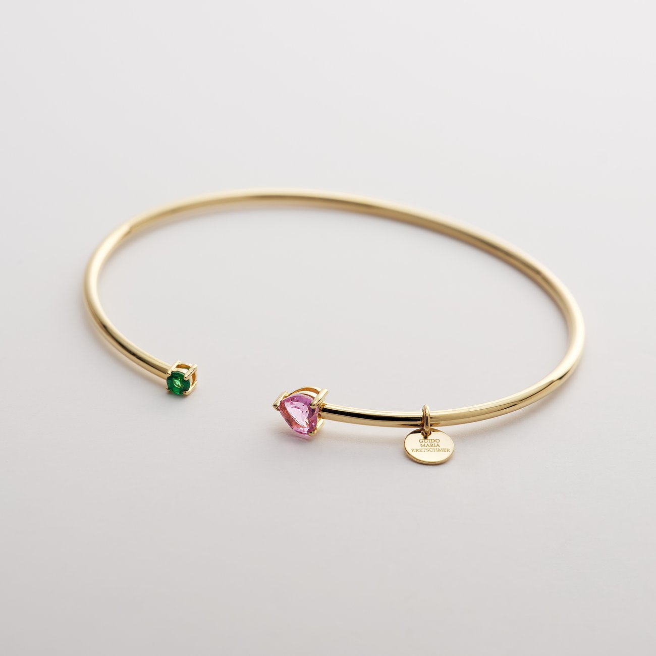 Das Guido Maria Kretschmer Armband aus recyceltem Silber ist mit einem grünen und einem pinken Zirkonia-Farbstein besetzt.