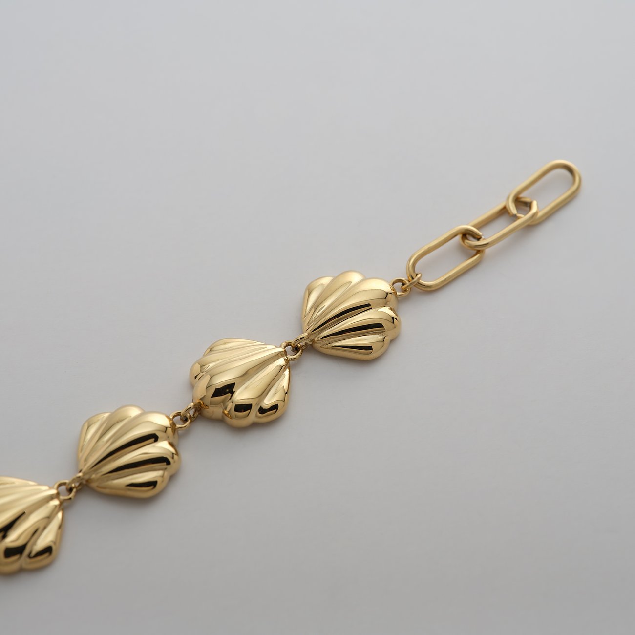 Bracelet Guido Maria Kretschmer en acier inoxydable plaqué or jaune avec trois éléments en forme de coquille.