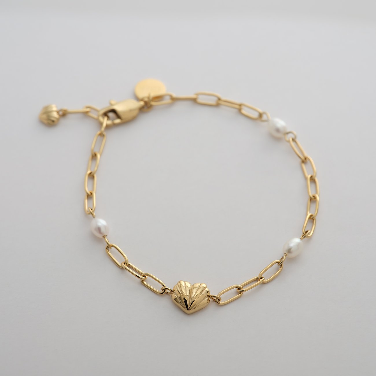 Guido Maria Kretschmer armbandsmycke i guldfärgat rostfritt stål med kedja, hjärta och pärlor.