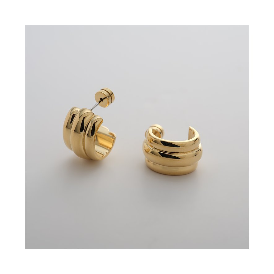 Zwei Guido Maria Kretschmer Creolen aus glänzendem goldfarbenem Edelstahl. Die Ohrringe sind breit und geriffelt.