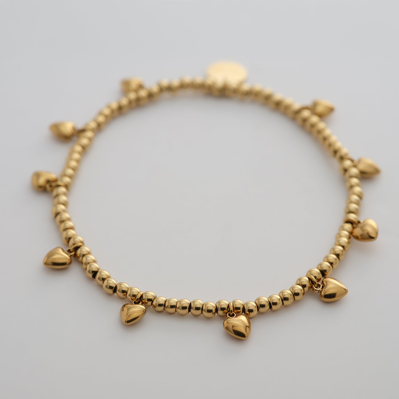 Bracciale aderente Guido Maria Kretschmer in acciaio inossidabile color oro con tanti piccoli cuori.