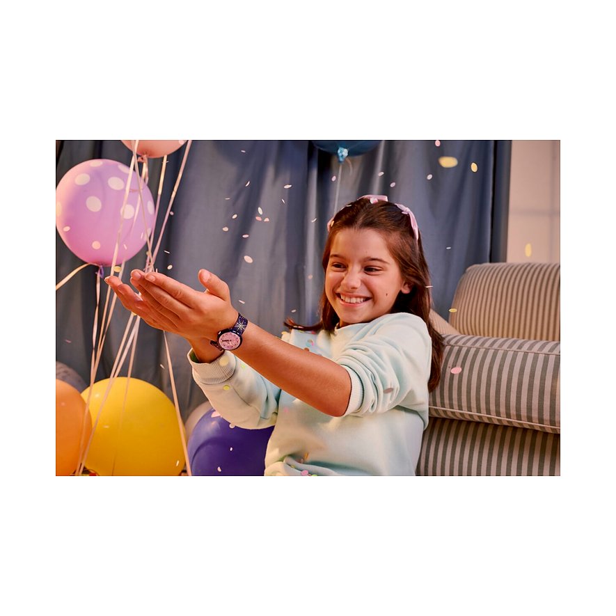 Ein lächelndes Mädchen fängt Konfetti mit ihren Händen. Sie trägt eine Flik Flak Kinder-/Jugenduhr.