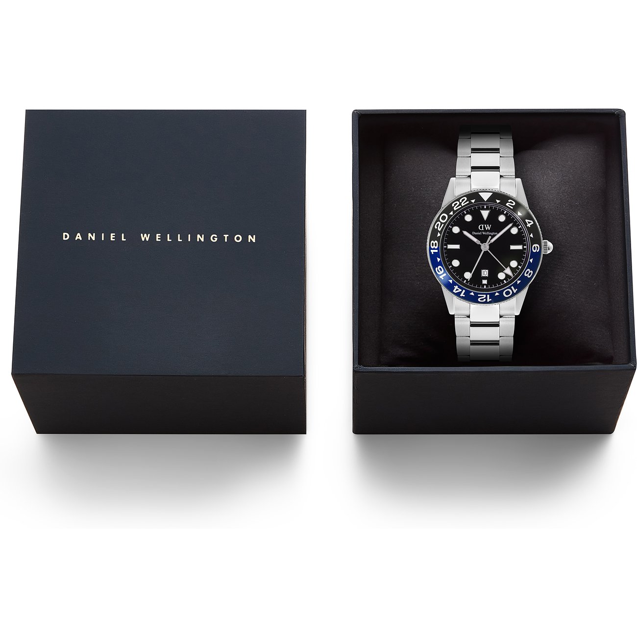 Die Daniel Wellington Herrenuhr aus Edelstahl in einer offenen Geschenkbox. Neben der Uhr liegt die andere Boxhälfte.