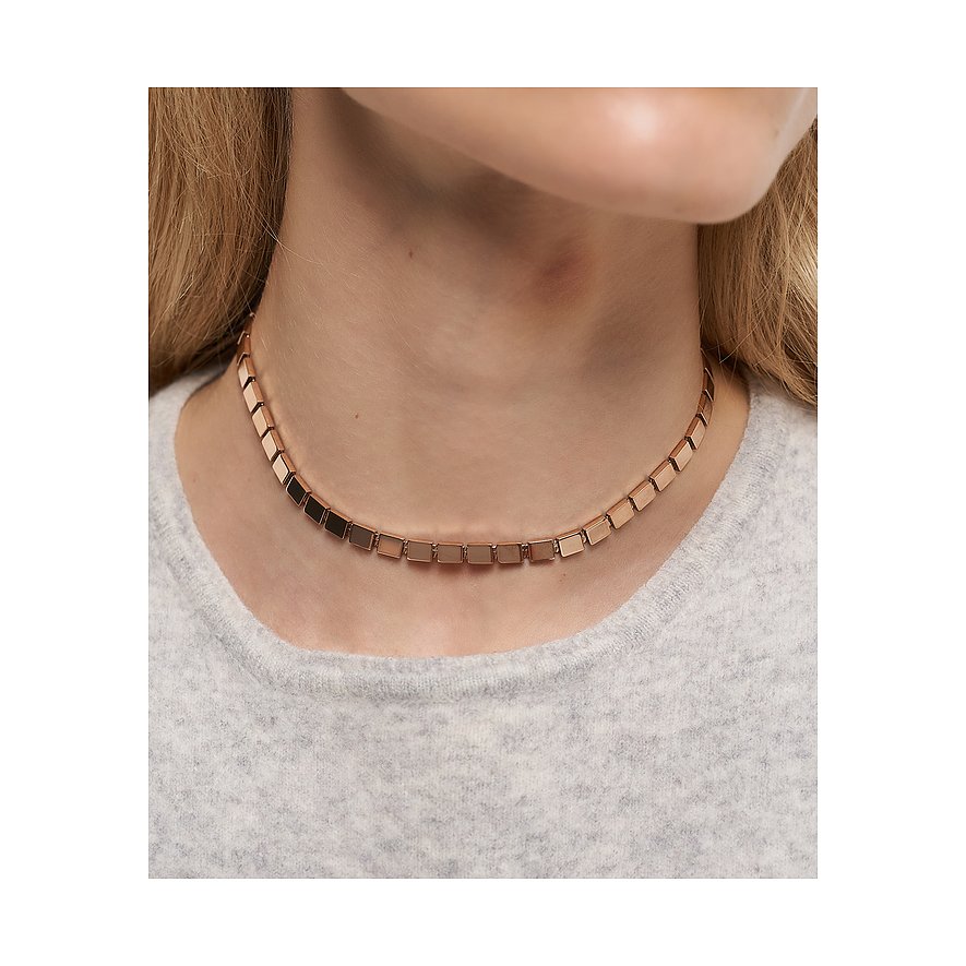 Am Hals einer Frau, Nahaufnahme, eine Liebeskind Halskette aus roségoldfarbenem Edelstahl mit eckigen Gliedern.