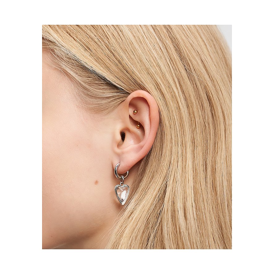 Nærbillede af en person med blondt hår, iført en sølv Liebeskind hjerteørering i rustfrit stål.