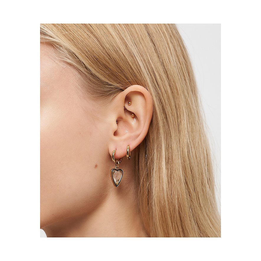 Ein blondes Ohr trägt einen Liebeskind Edelstahl Ohrring mit einem herzförmigen, klaren Steinanhänger