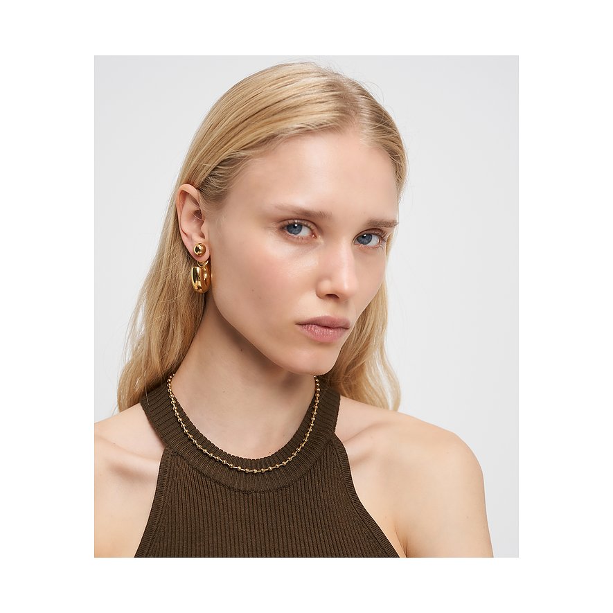 Model trägt eine goldfarbene Liebeskind Halskette aus Edelstahl, die eng am Hals anliegt.