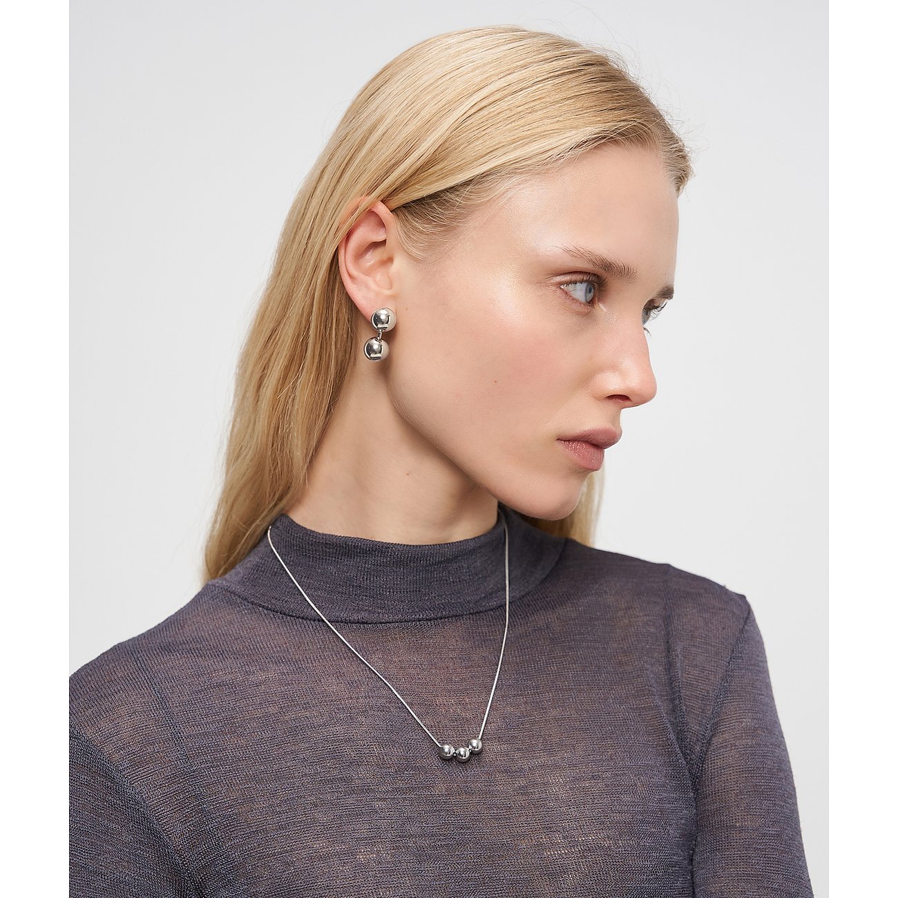 Mannequin portant un collier Liebeskind en acier inoxydable poli avec trois perles rondes, assorti aux boucles.