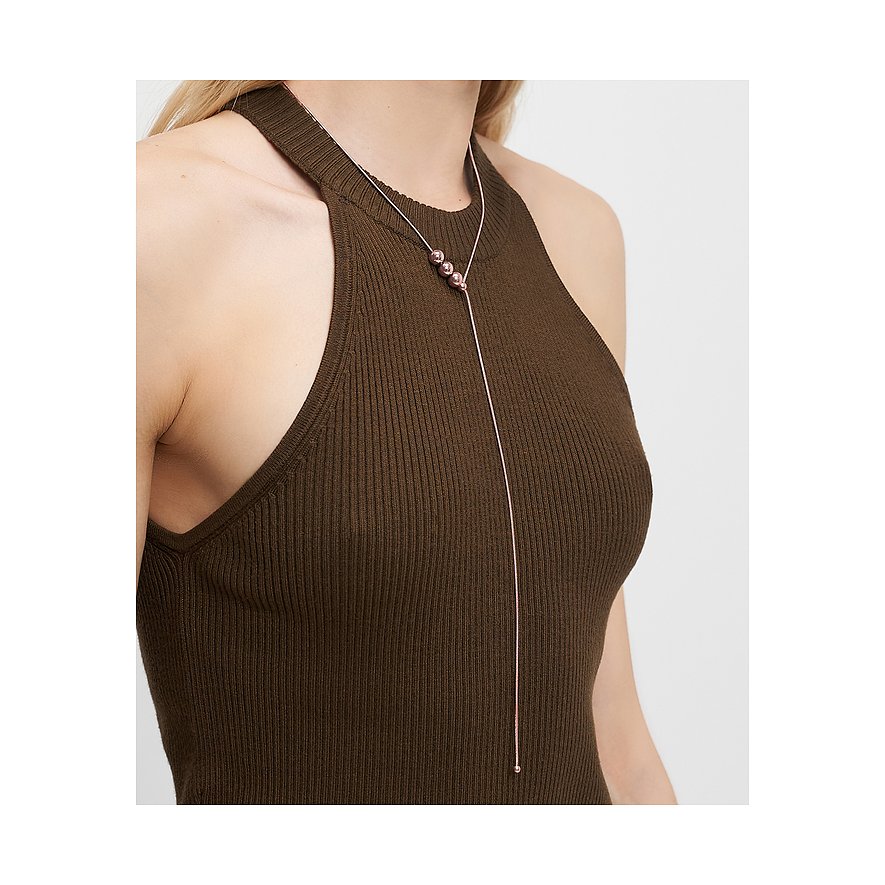 Nahaufnahme einer Frau, die eine Liebeskind Halskette aus Edelstahl mit drei roségoldenen Kugeln trägt.