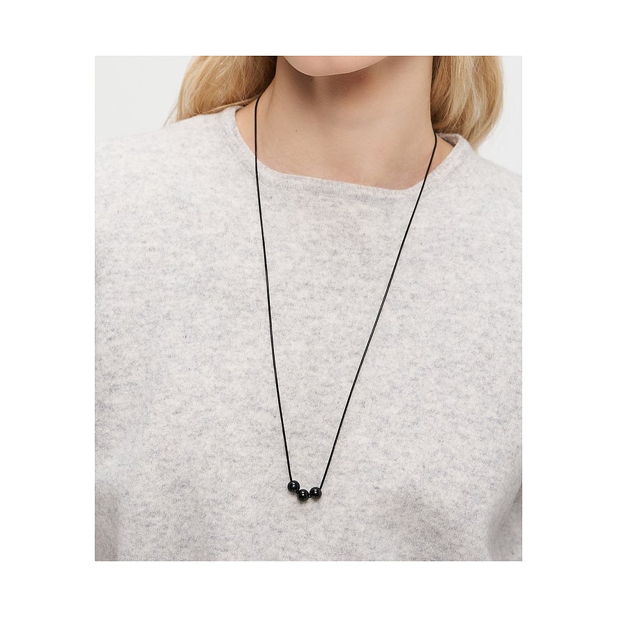 Närbild av kvinna med Liebeskind halsband: svart tråd med tre kulor i rostfritt stål.