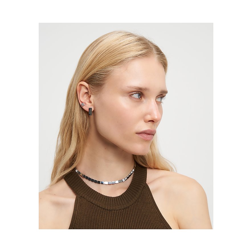 Close-up van een model met Liebeskind roestvrijstalen oorbellen, bestaande uit vierkante en rechthoekige studs.