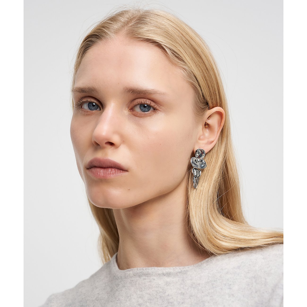 Nahaufnahme einer Frau mit einem Liebeskind Ohrring aus Edelstahl in einer organischen Form am rechten Ohr.