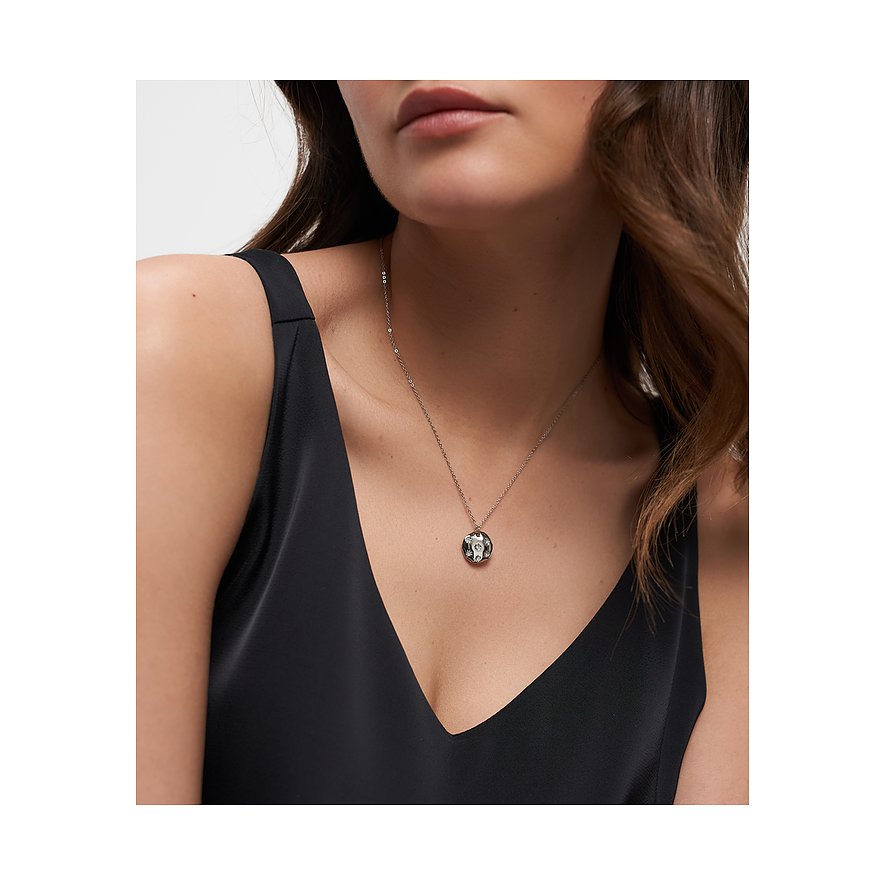 Frau trägt kurze Tamaris Edelstahlkette mit rundem Anhänger, der in der Mitte mit einem Zirkonia besetzt ist.