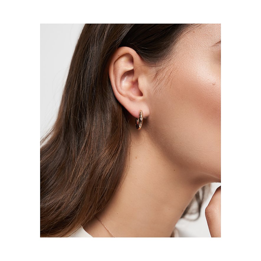 Am Ohr einer Frau ist ein Tamaris Creolen-Ohrring aus roségoldfarbenem Edelstahl mit glänzenden Glassteinen zu sehen.